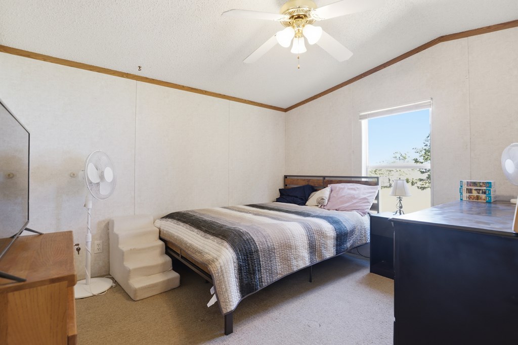 912 Alamo Road Fredericksburg, TX 78624 - Photo 12 of 21 a bedroom with a bed and a chandelier