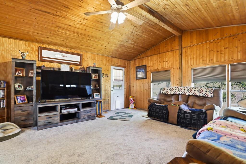 912 Alamo Road Fredericksburg, TX 78624 - Photo 13 of 21 a living room with furniture a flat screen tv and a floor to ceiling window