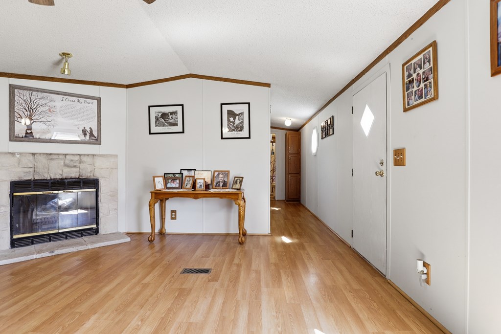 912 Alamo Road Fredericksburg, TX 78624 - Photo 5 of 21 a view of a hallway with wooden floor and a fireplace