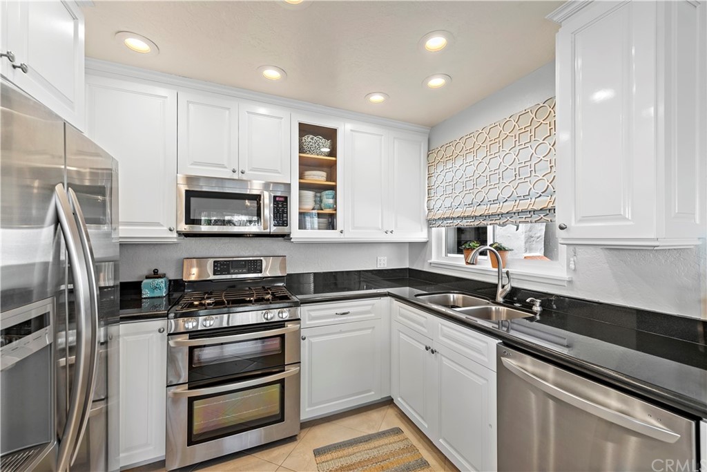 312 Avenida Granada, Unit A San Clemente, CA 92672 - Photo 13 of 25 a kitchen with granite countertop a sink stainless steel appliances and cabinets