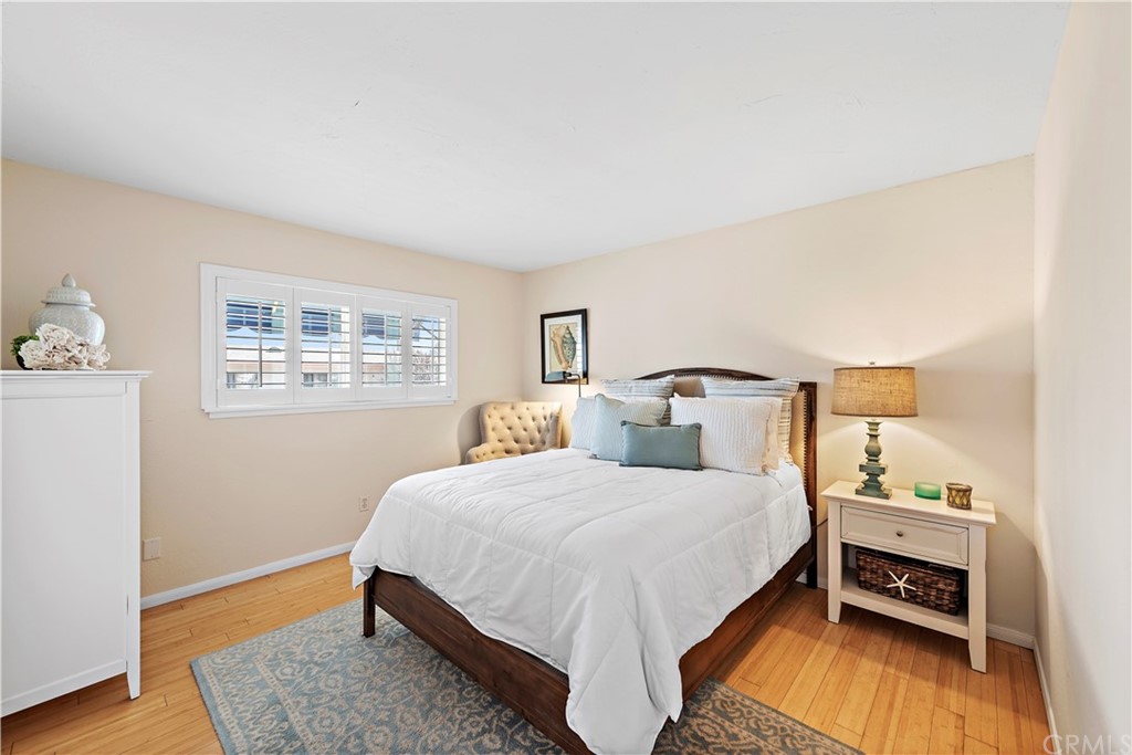 312 Avenida Granada, Unit A San Clemente, CA 92672 - Photo 17 of 25 a bedroom with a bed and wooden floor