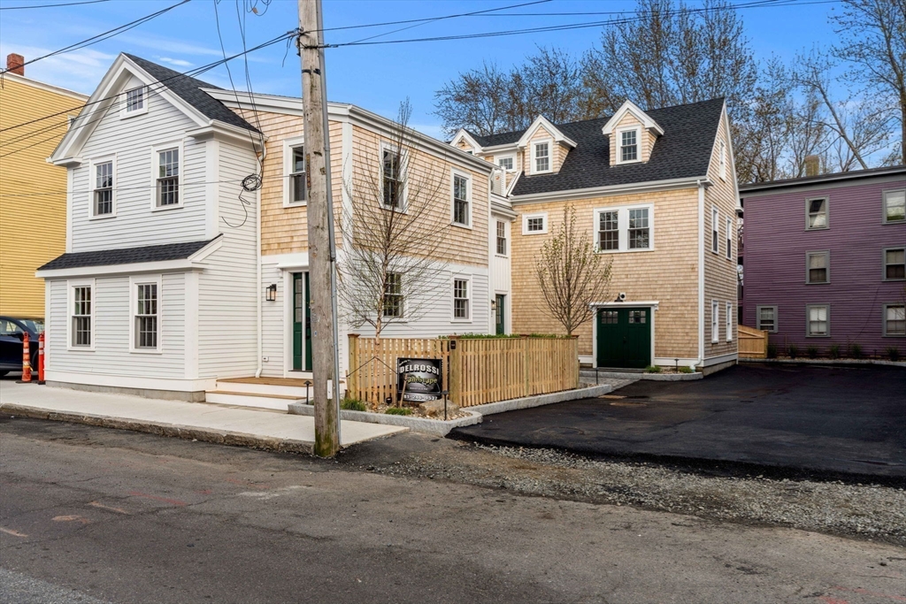 a view of a white house with a large space in front of it