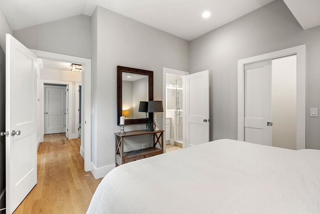 143 Derby Street, Unit 1 Salem, MA 01970 - Photo 31 of 42 a bed room with a bed and a large mirror