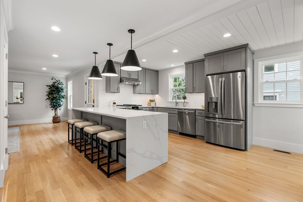 143 Derby Street, Unit 1 Salem, MA 01970 - Photo 8 of 42 a kitchen with granite countertop a refrigerator and wooden floors
