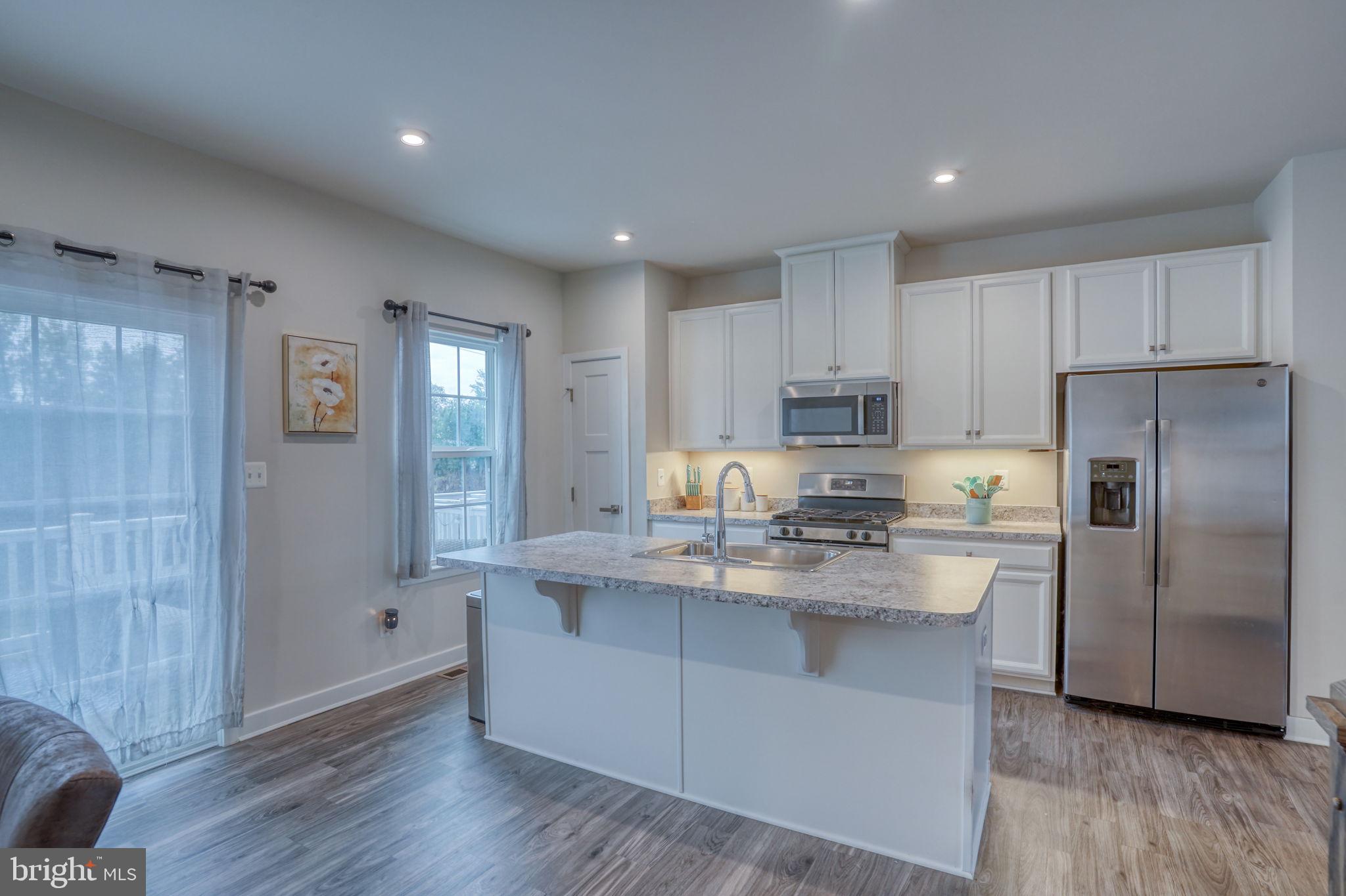 1944 Spearfish Court Newark, DE 19702 - Photo 17 of 44 a kitchen with kitchen island white cabinets and stainless steel appliances