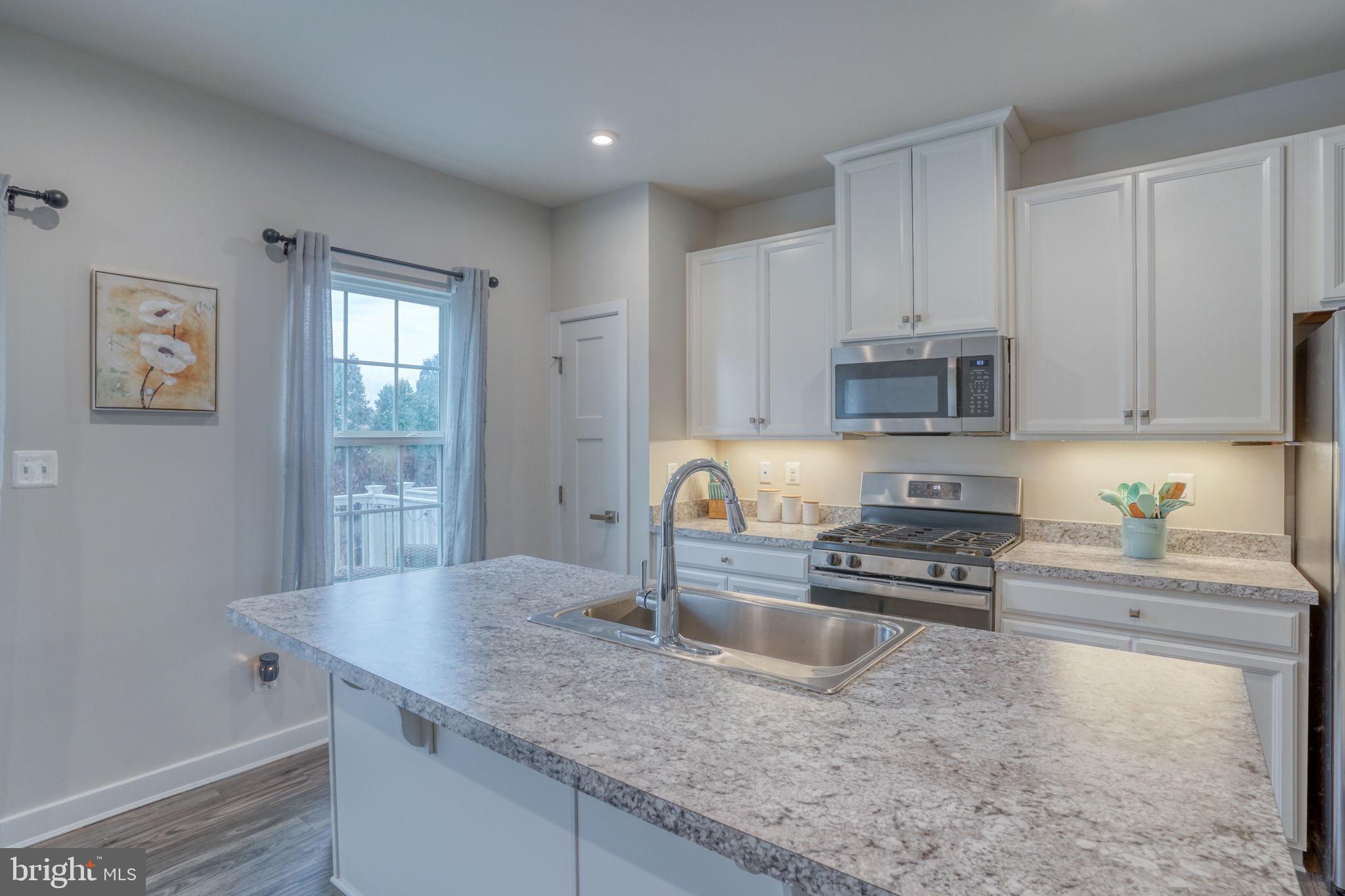 1944 Spearfish Court Newark, DE 19702 - Photo 18 of 44 a kitchen with granite countertop a sink a stove and cabinets