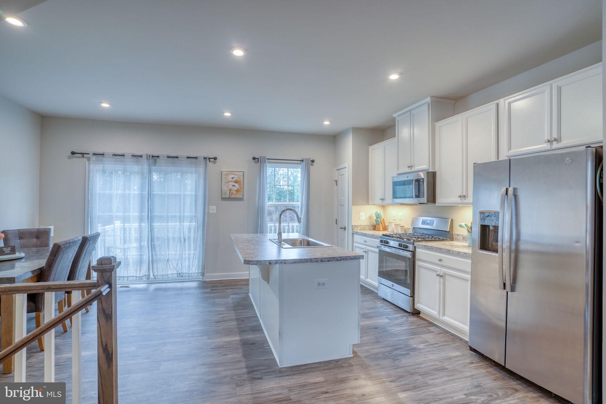 1944 Spearfish Court Newark, DE 19702 - Photo 19 of 44 a kitchen with kitchen island white cabinets and stainless steel appliances
