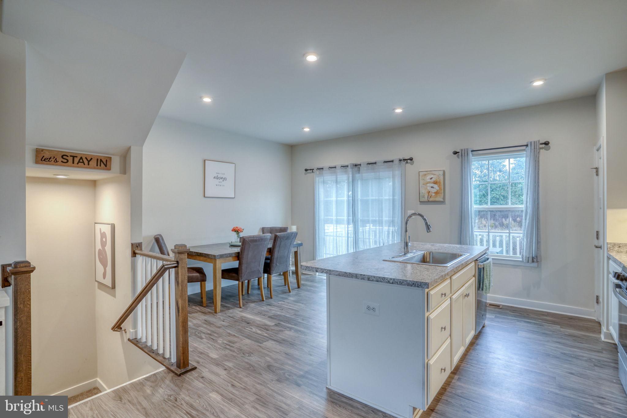 1944 Spearfish Court Newark, DE 19702 - Photo 20 of 44 a kitchen with stainless steel appliances granite countertop kitchen island a dining table chairs and wooden floor