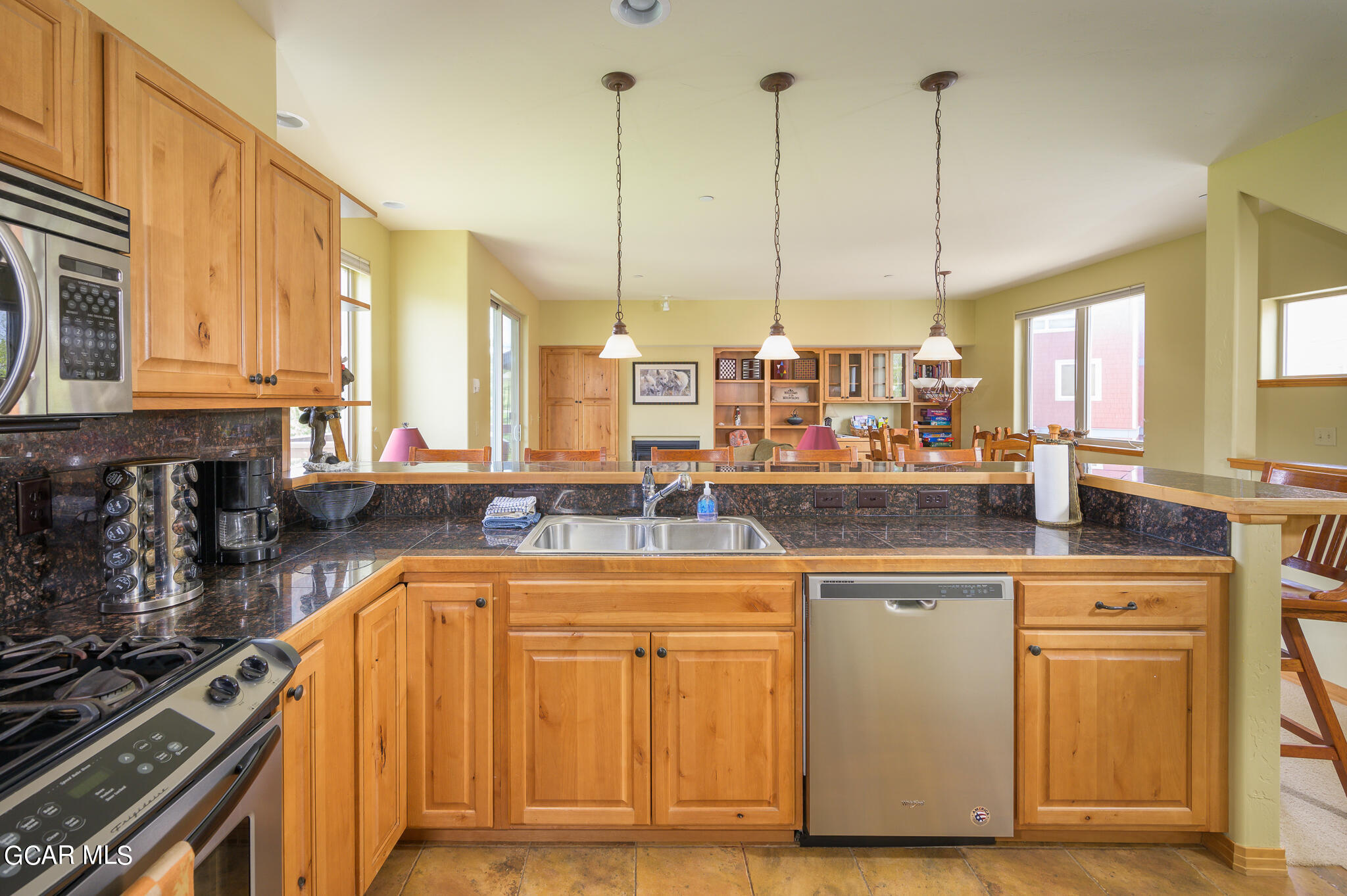 a kitchen with stainless steel appliances granite countertop a stove a sink and a wooden floors