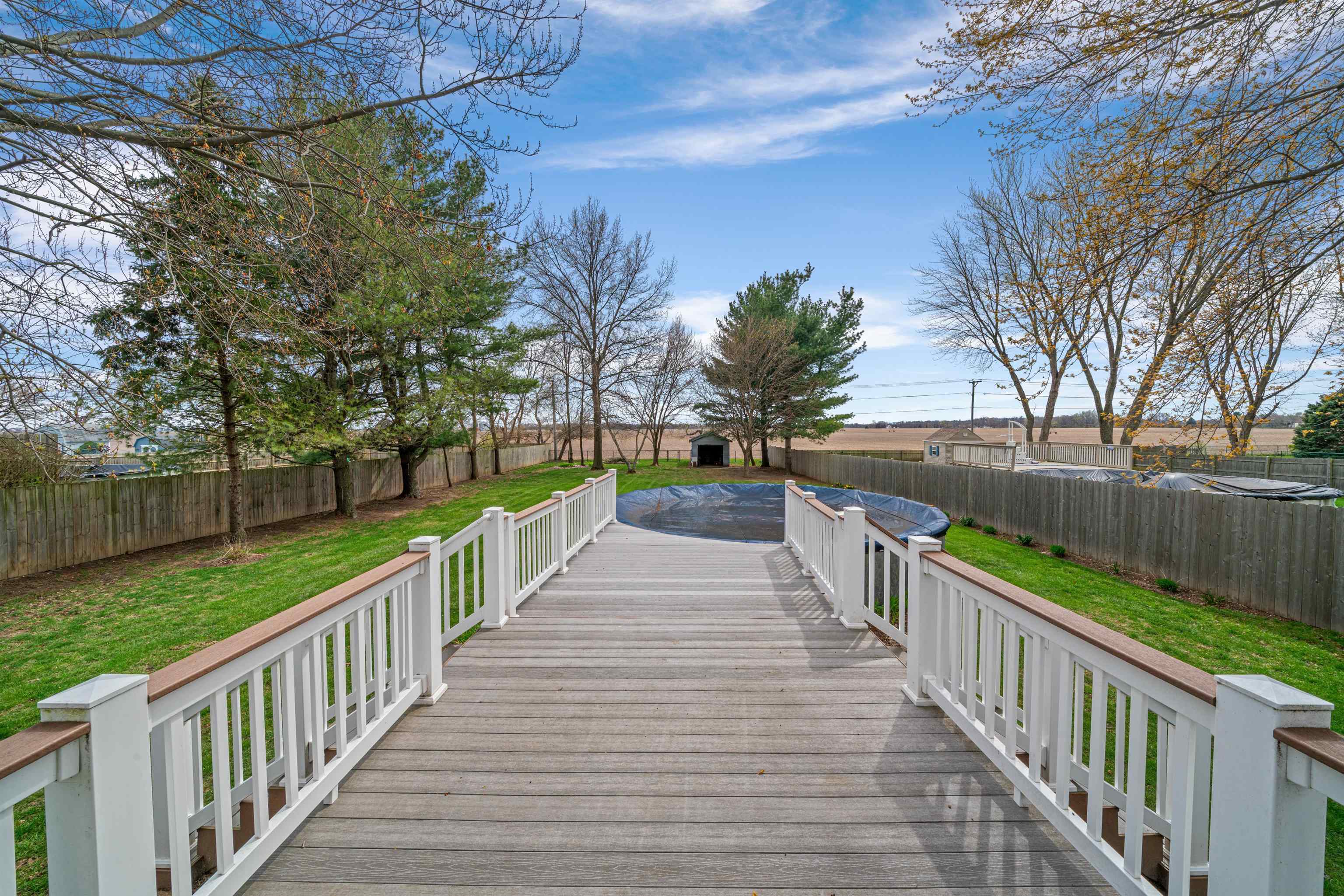 924 Suzy Street Sandwich, IL 60548 - Photo 36 of 48 a view of a deck and trees with wooden fence