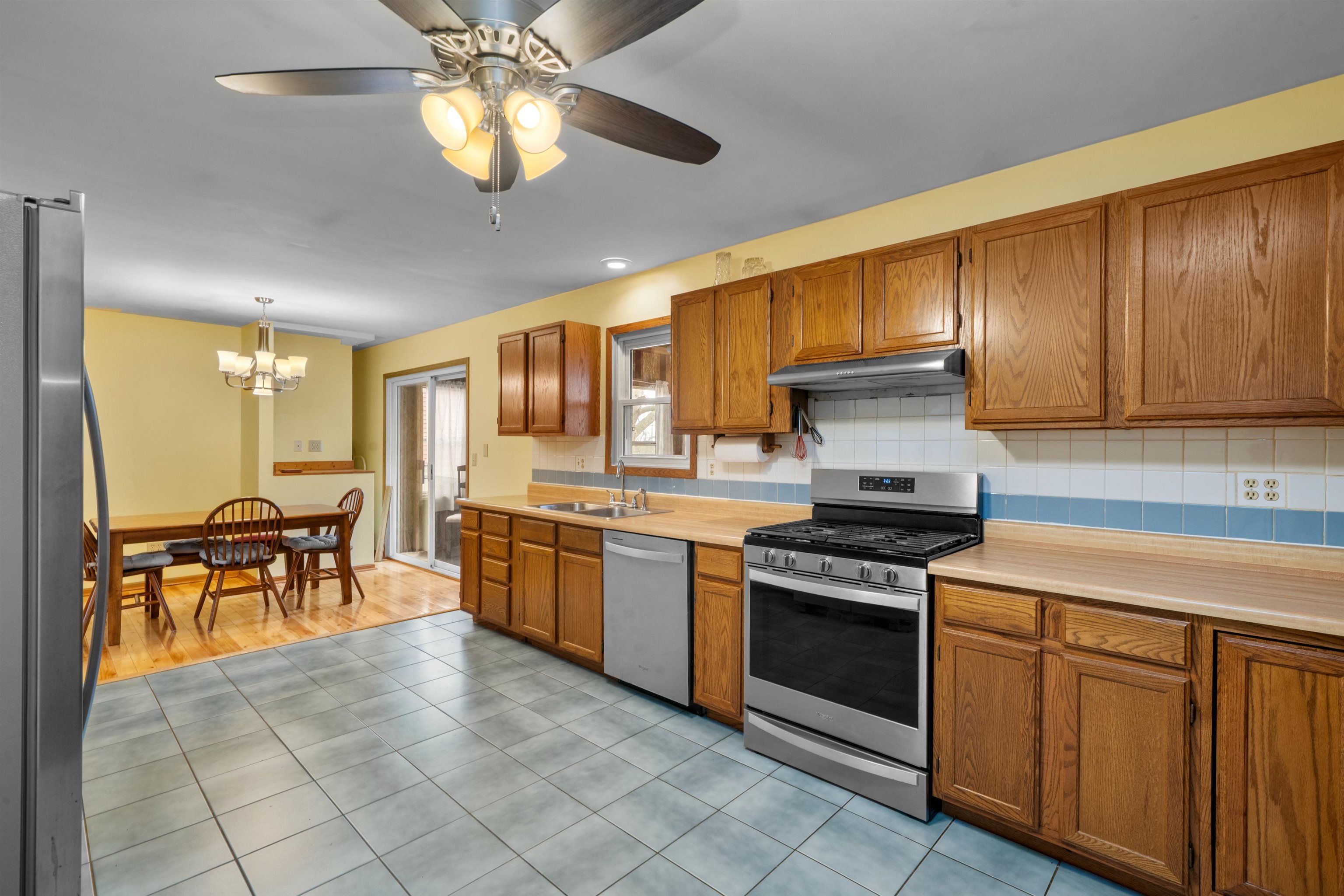 924 Suzy Street Sandwich, IL 60548 - Photo 9 of 48 a kitchen with stainless steel appliances granite countertop a stove top oven a sink dishwasher a dining table and chairs with wooden floor