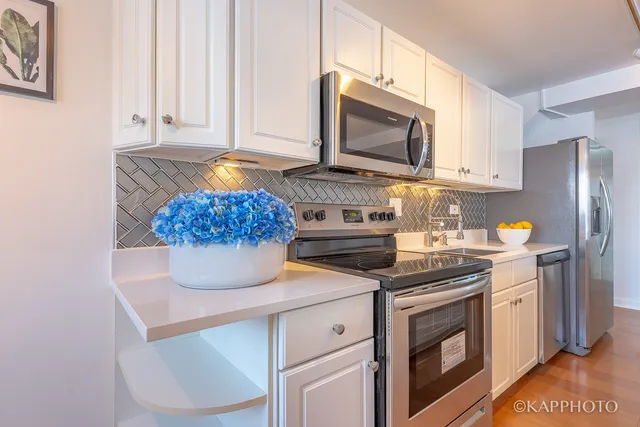 a kitchen with stainless steel appliances a stove a microwave a sink and cabinets