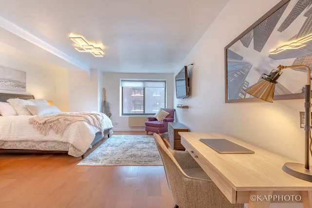 a bedroom with a bed and chandelier