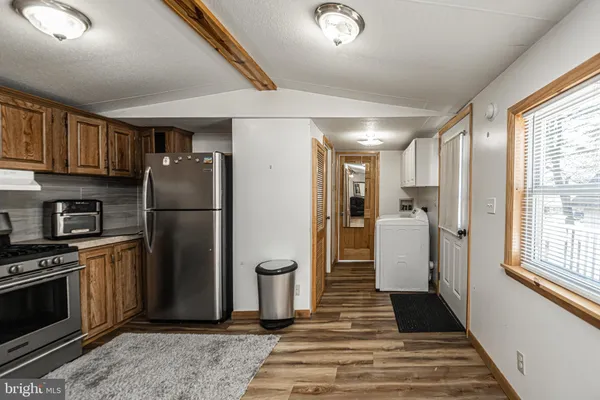 a kitchen with stainless steel appliances granite countertop a refrigerator a stove and a sink