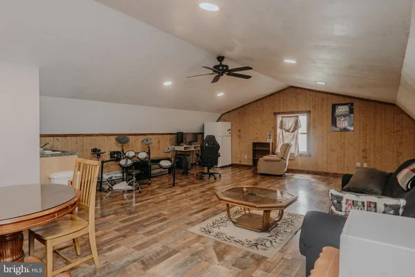 a living room with furniture and a dining table with wooden floor