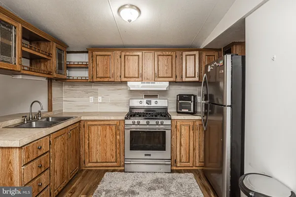 a kitchen with stainless steel appliances granite countertop a stove a refrigerator and a sink
