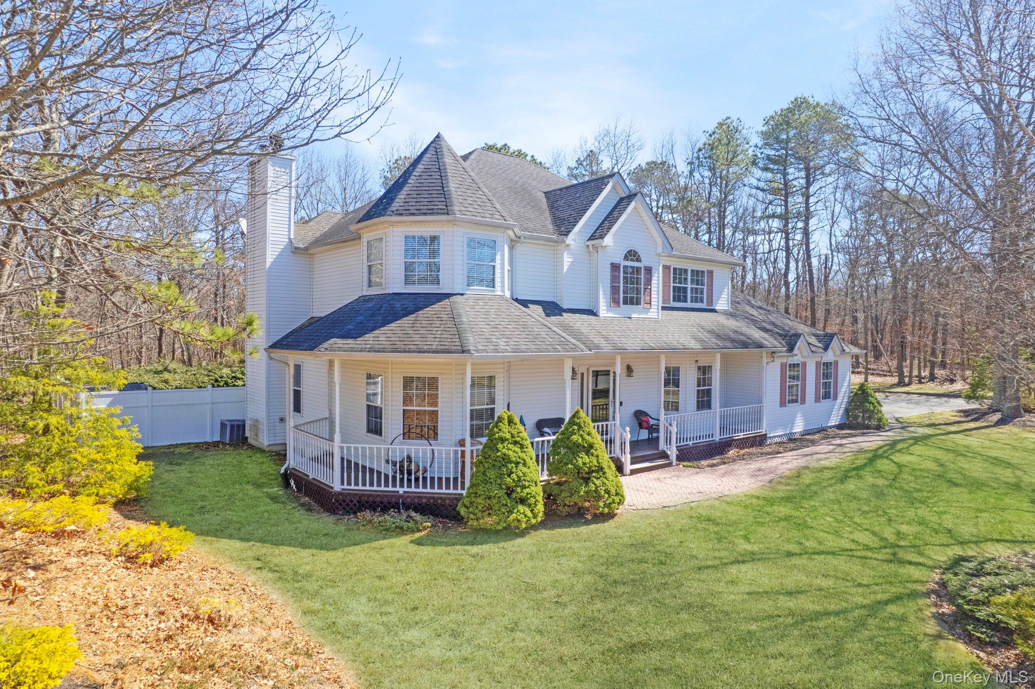 a view of a house with a big yard plants and large trees