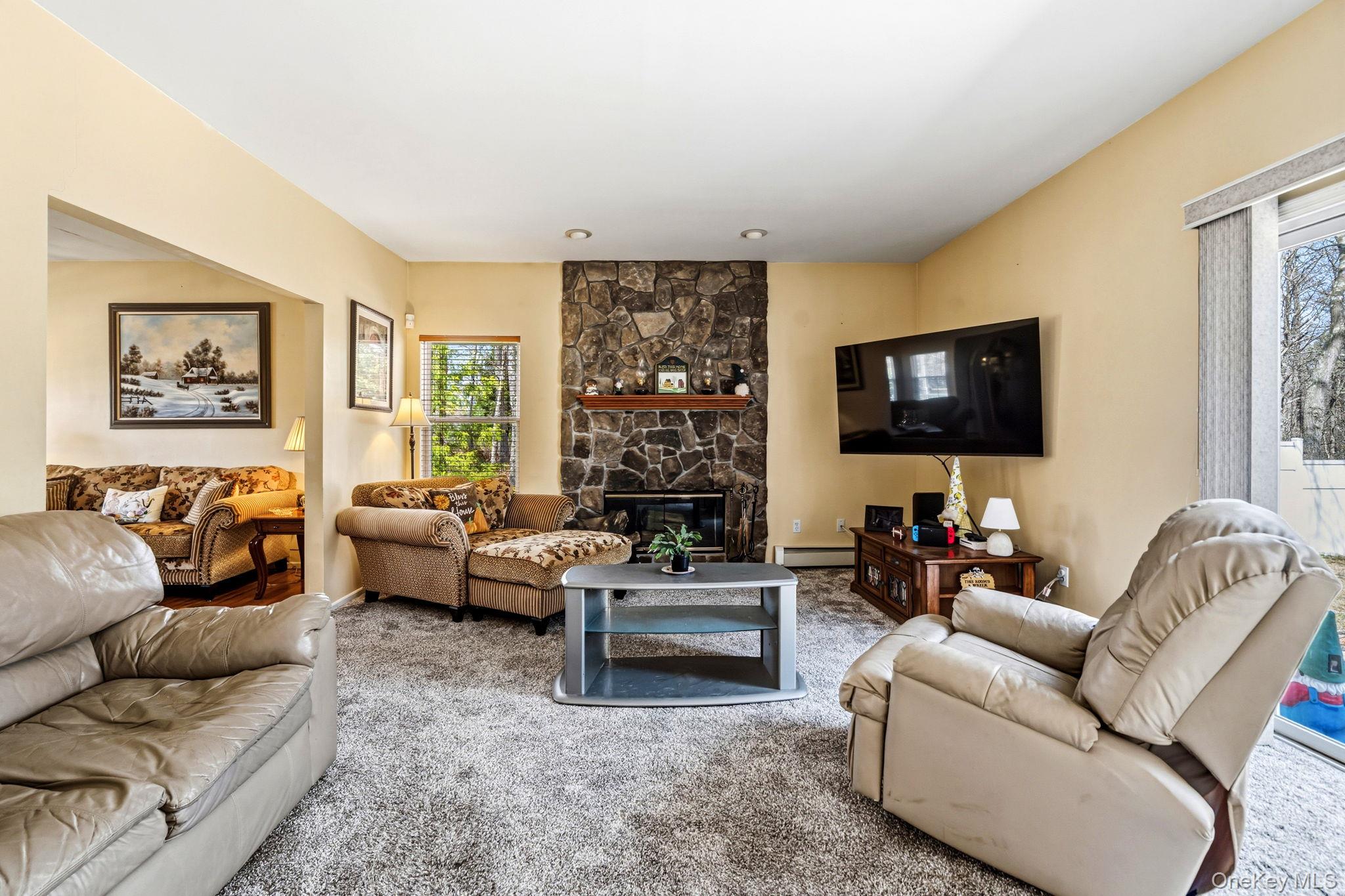 20 Ricky Road Manorville, NY 11949 - Photo 11 of 27 a living room with furniture and a flat screen tv