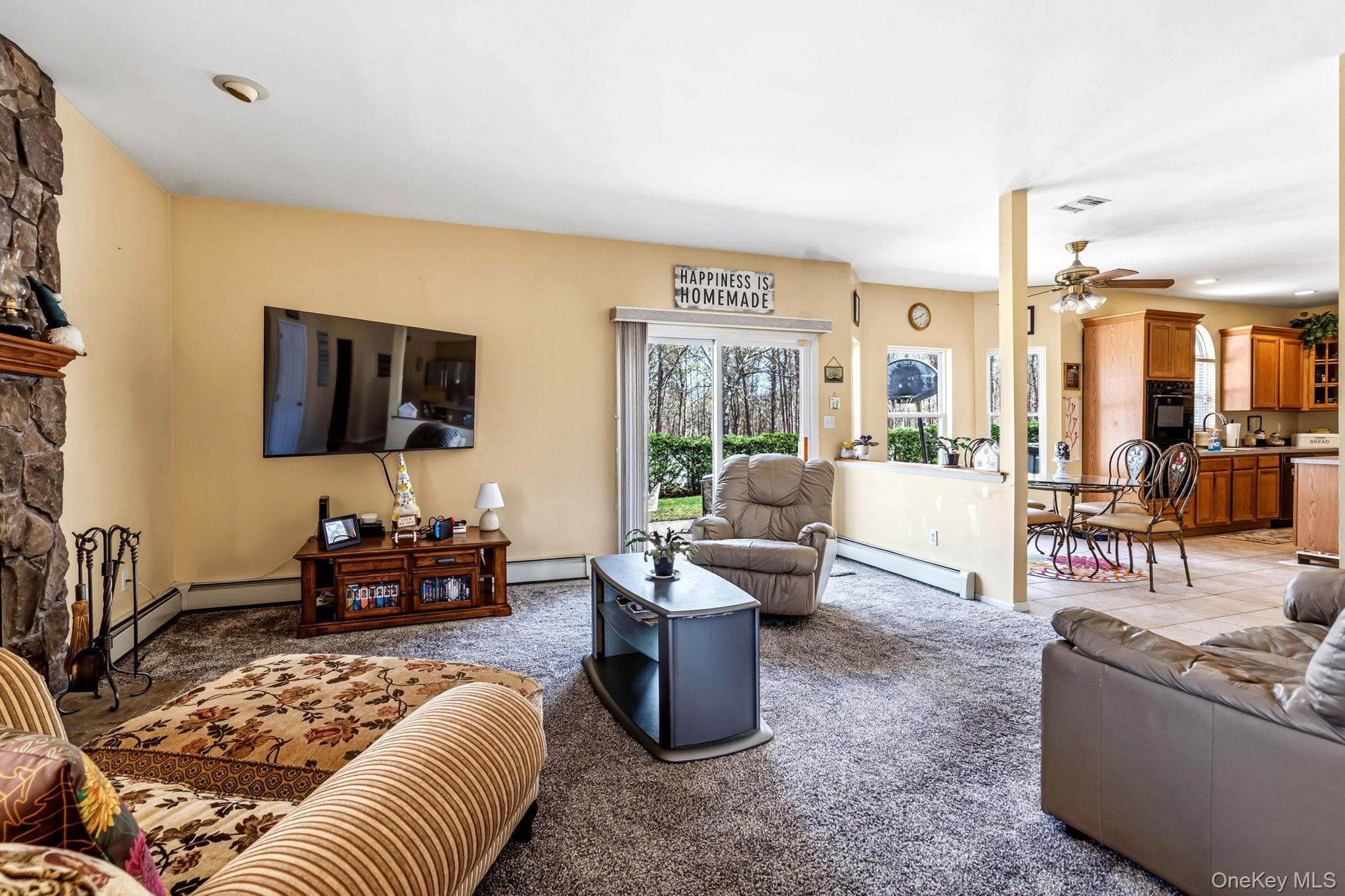 20 Ricky Road Manorville, NY 11949 - Photo 13 of 27 a living room with furniture and a flat screen tv