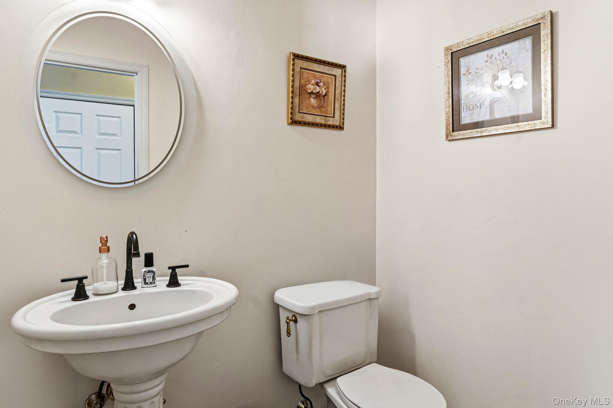 20 Ricky Road Manorville, NY 11949 - Photo 14 of 27 a bathroom with a toilet a sink and a mirror