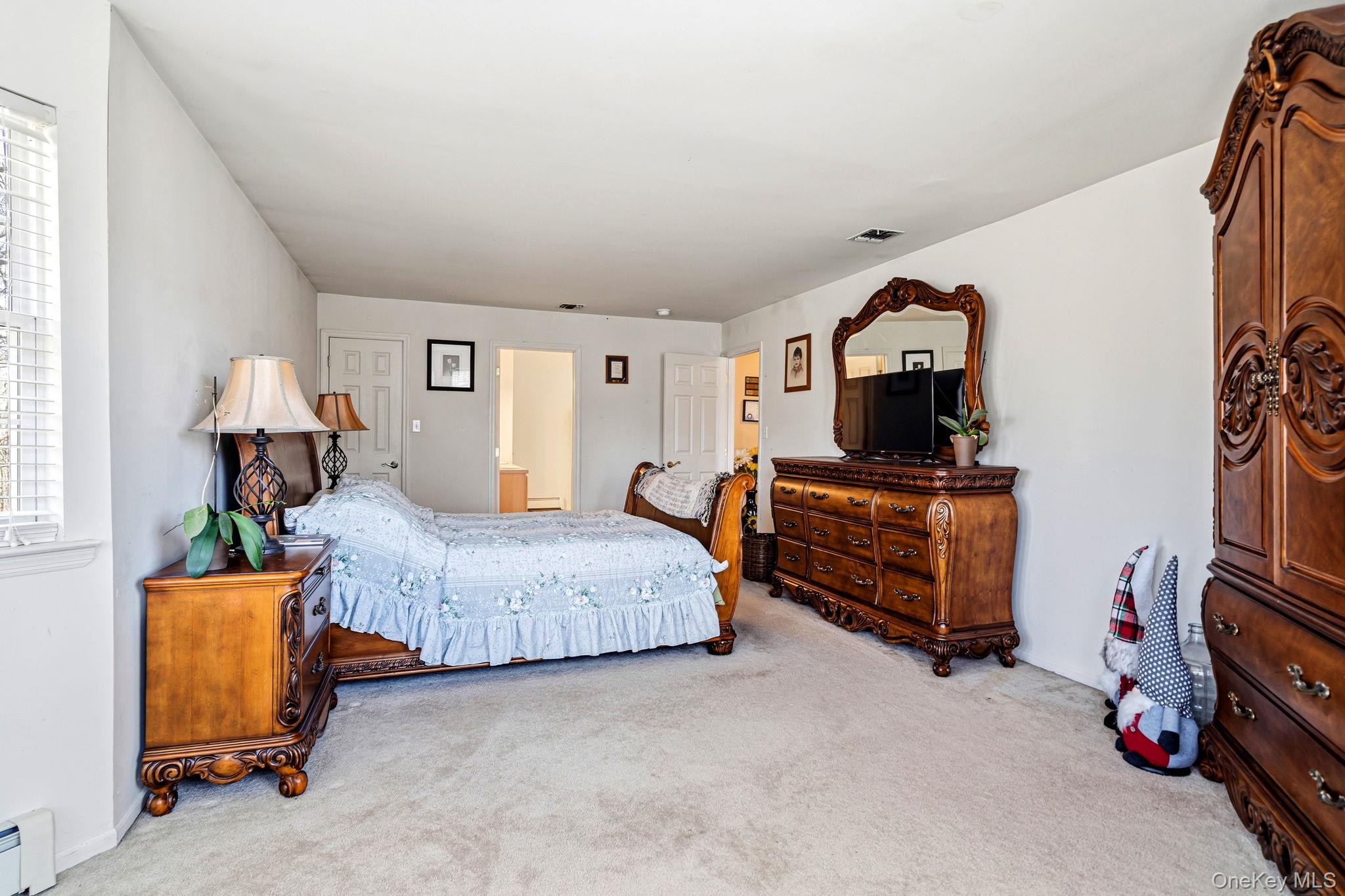 20 Ricky Road Manorville, NY 11949 - Photo 19 of 27 a bedroom with a bed and a tv on the dresser