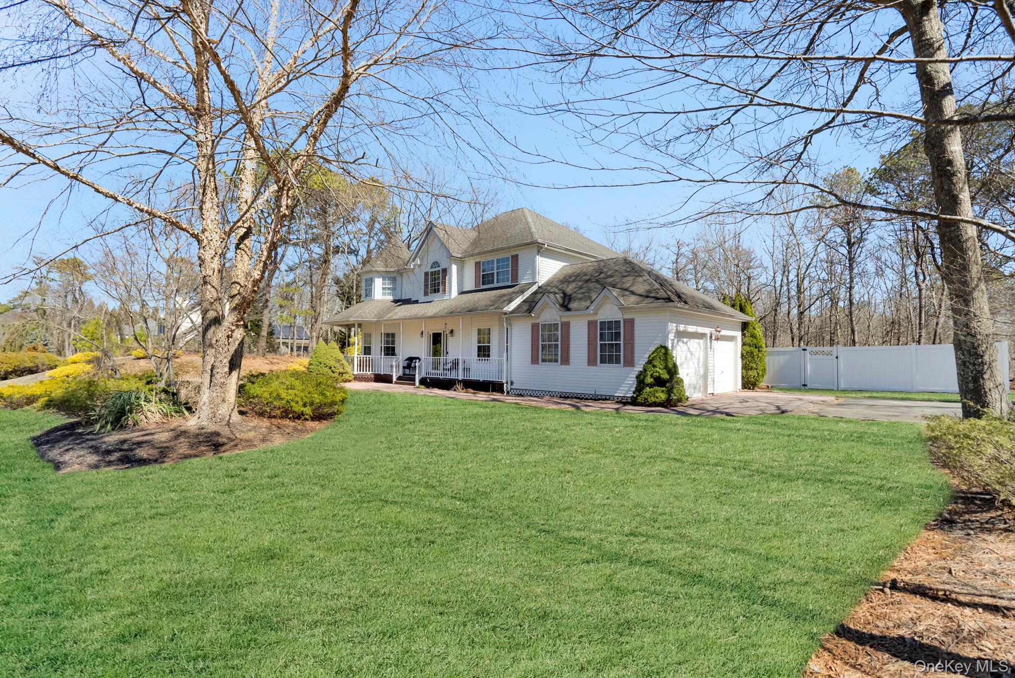 20 Ricky Road Manorville, NY 11949 - Photo 2 of 27 a front view of a house with a garden and trees