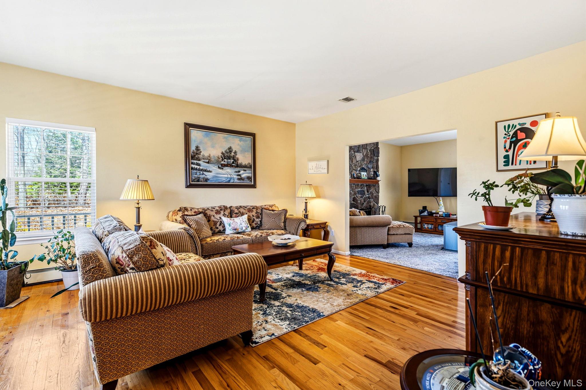 20 Ricky Road Manorville, NY 11949 - Photo 5 of 27 a living room with furniture or couch and a flat screen tv