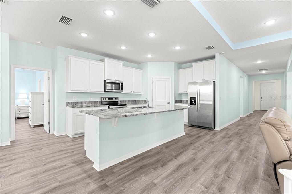 5851 Southwest 85th Place Ocala, FL 34476 - Photo 7 of 57 a kitchen with stainless steel appliances granite countertop a refrigerator sink and white cabinets
