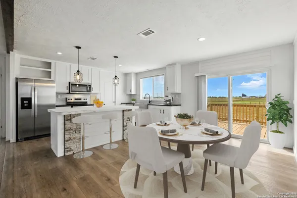 a kitchen with a dining table chairs and refrigerator