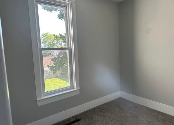 an empty room with wooden door and closet