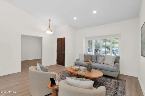 a living room with furniture a dining table and a chandelier