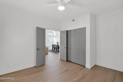 an empty room with a window and a fan