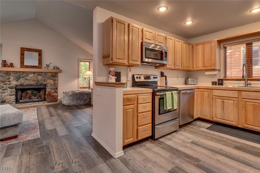 931 Incline Way, Unit 249 Incline Village, NV 89451 - Photo 13 of 21 a kitchen with stainless steel appliances granite countertop a stove top oven a sink dishwasher and a refrigerator with wooden floor
