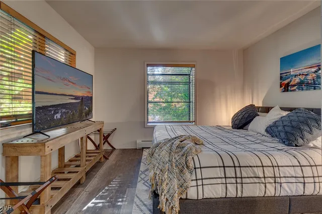 a bedroom with a bed and a painting on the wall