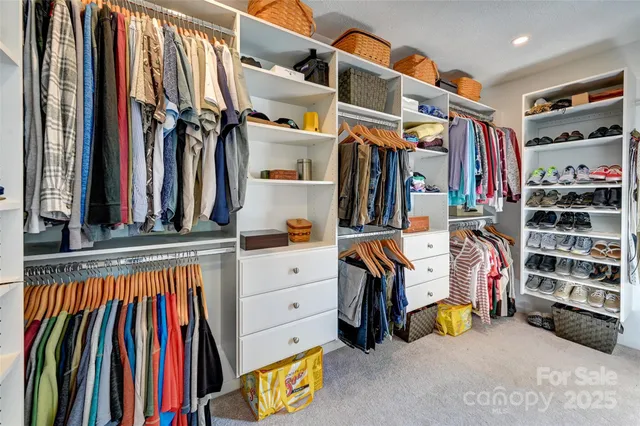 a view of walk in closet with clothes and shoes