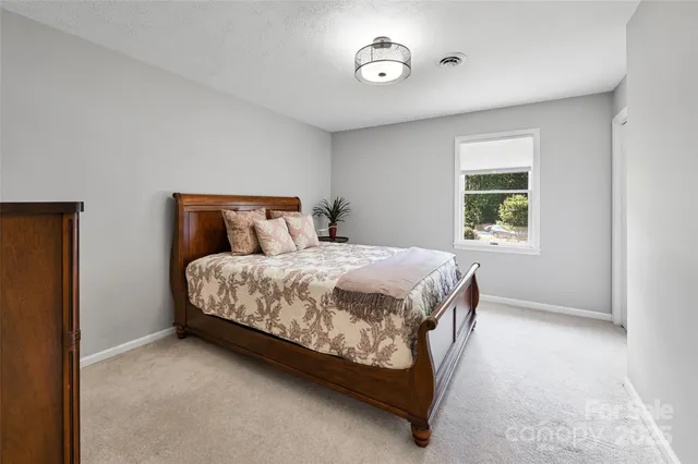 a bed sitting in a bedroom next to a window
