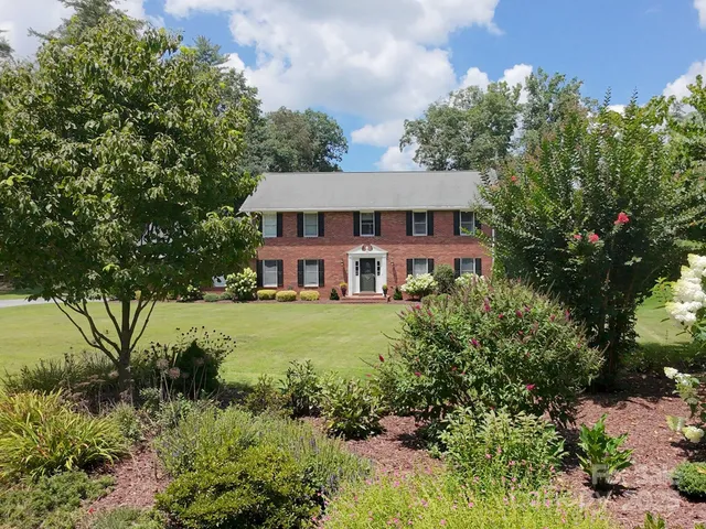 a view of a house with a yard and sitting area