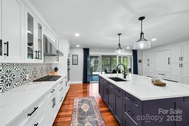 a large kitchen with kitchen island a sink stove and wooden floor