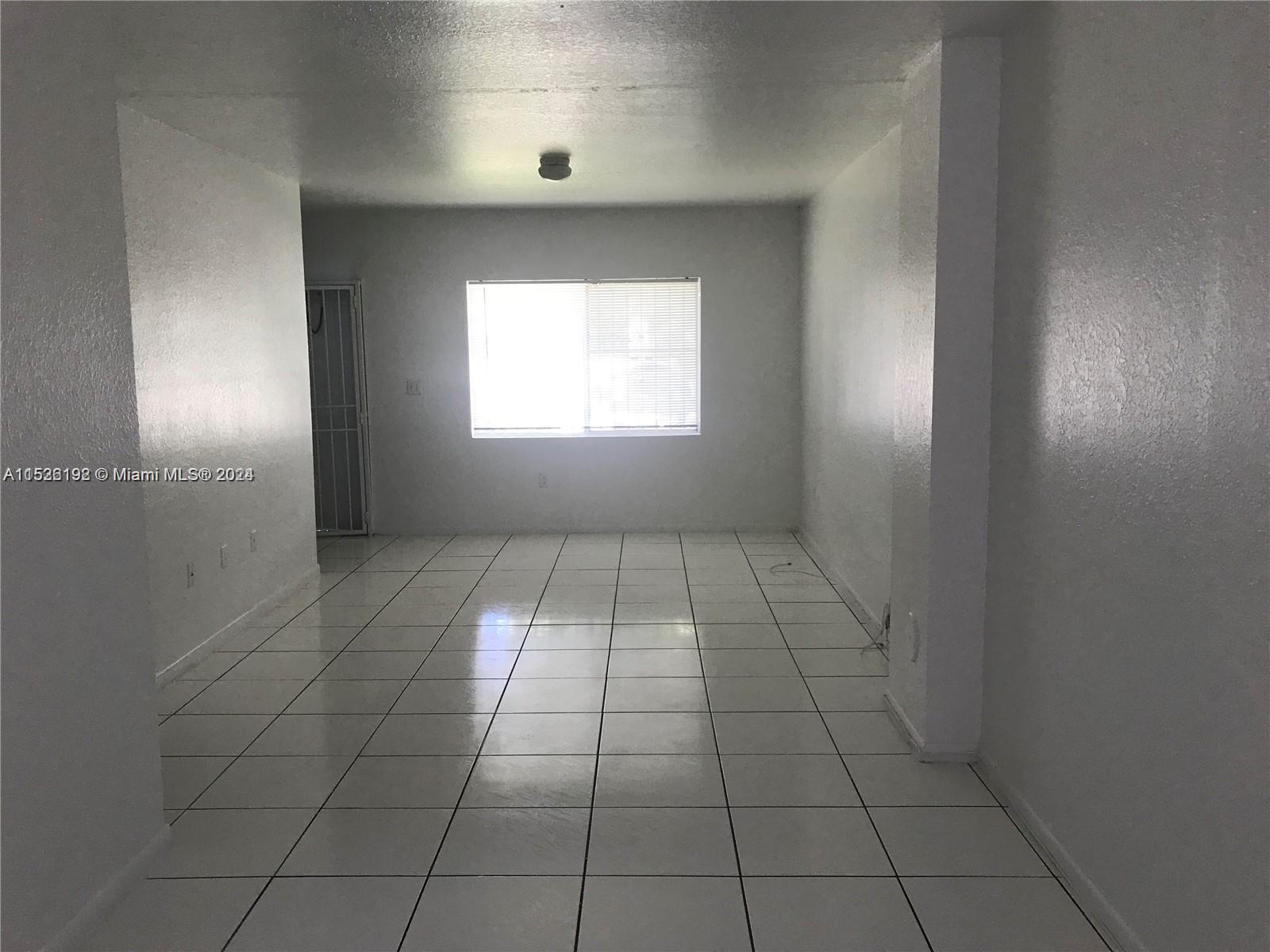 an empty room with white walls and tiles