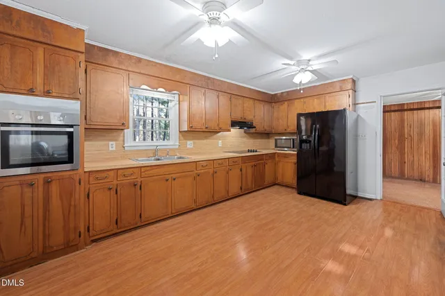 a large kitchen with a large window stainless steel appliances and cabinets
