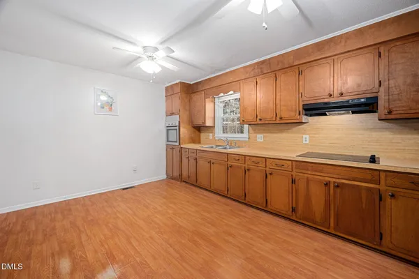 a kitchen with stainless steel appliances granite countertop a sink cabinets and wooden floor