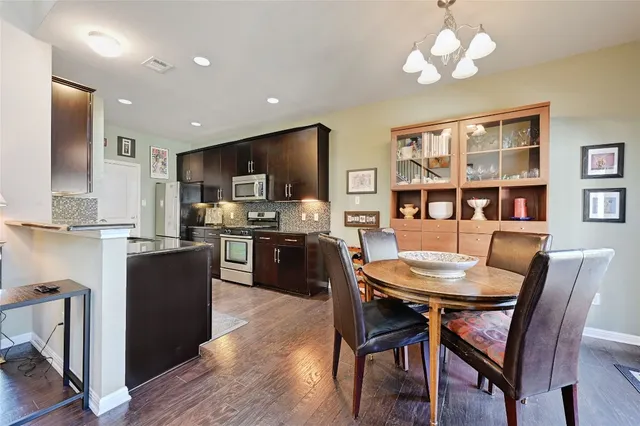 a view of a dining room with furniture a kitchen and chandelier