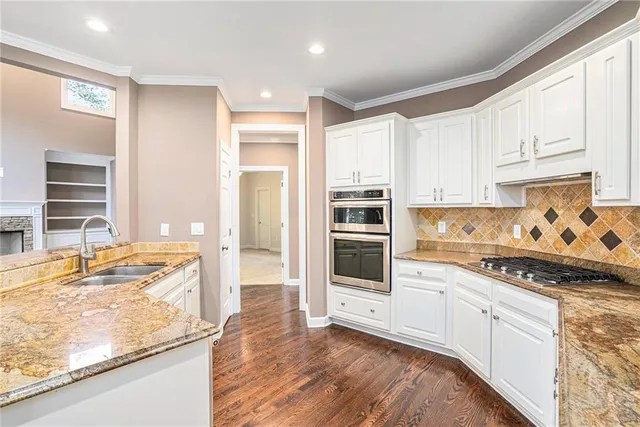 a kitchen with stainless steel appliances granite countertop a stove and a sink