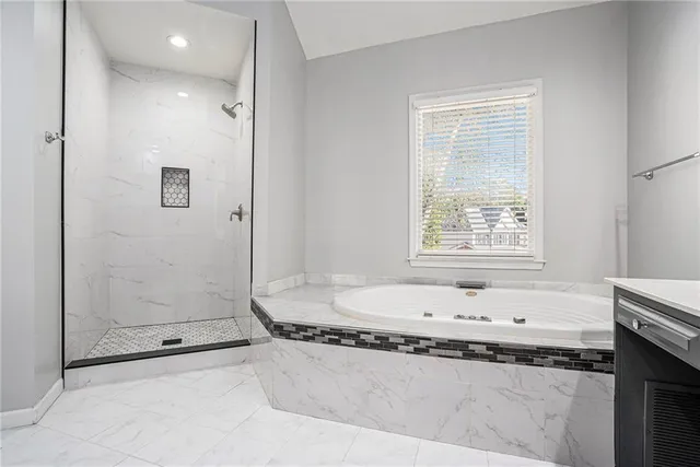 a bathroom with a granite countertop sink a mirror and a bathtub