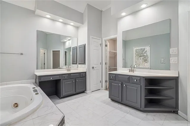 a spacious bathroom with a tub sink shower and mirror