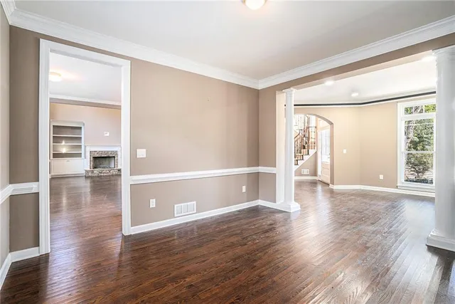 a view of empty room with wooden floor