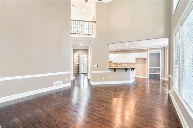 a view of a hallway with wooden floor and a kitchen