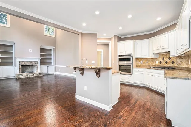 a kitchen with stainless steel appliances granite countertop a stove top oven a sink and a refrigerator