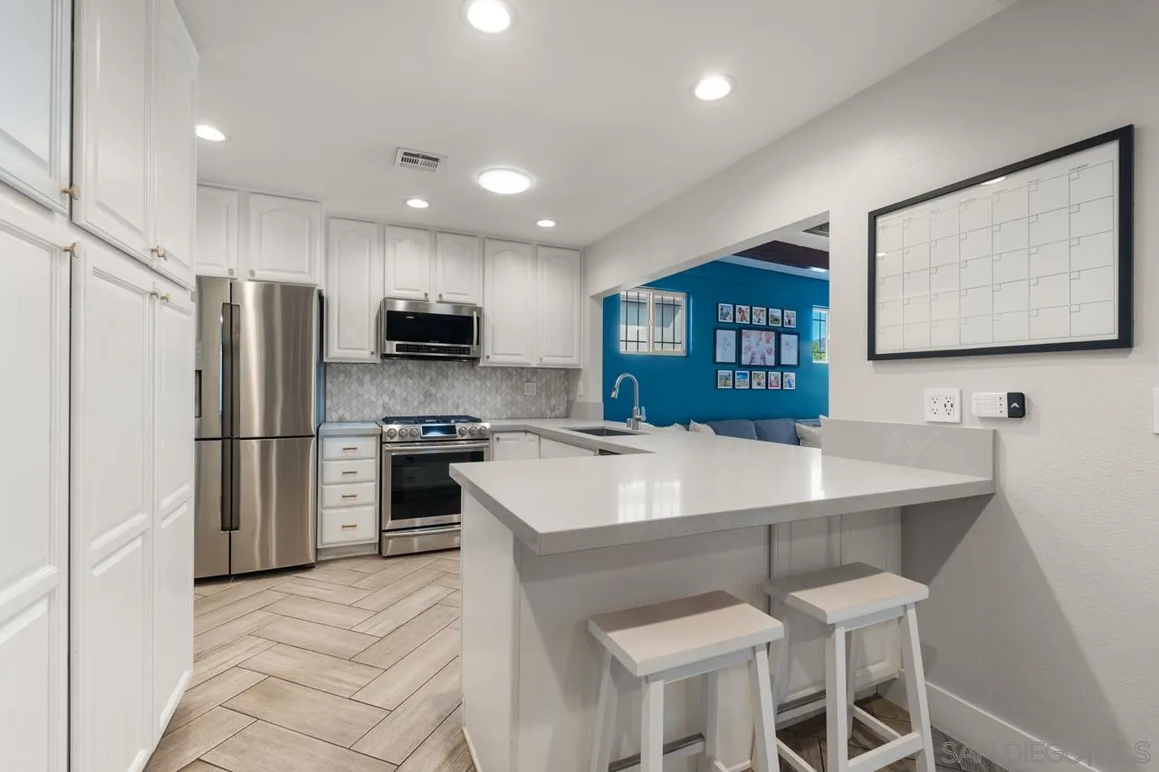 10113 Gem Tree Way Santee, CA 92071 - Photo 17 of 49 a kitchen with kitchen island a refrigerator stove and microwave