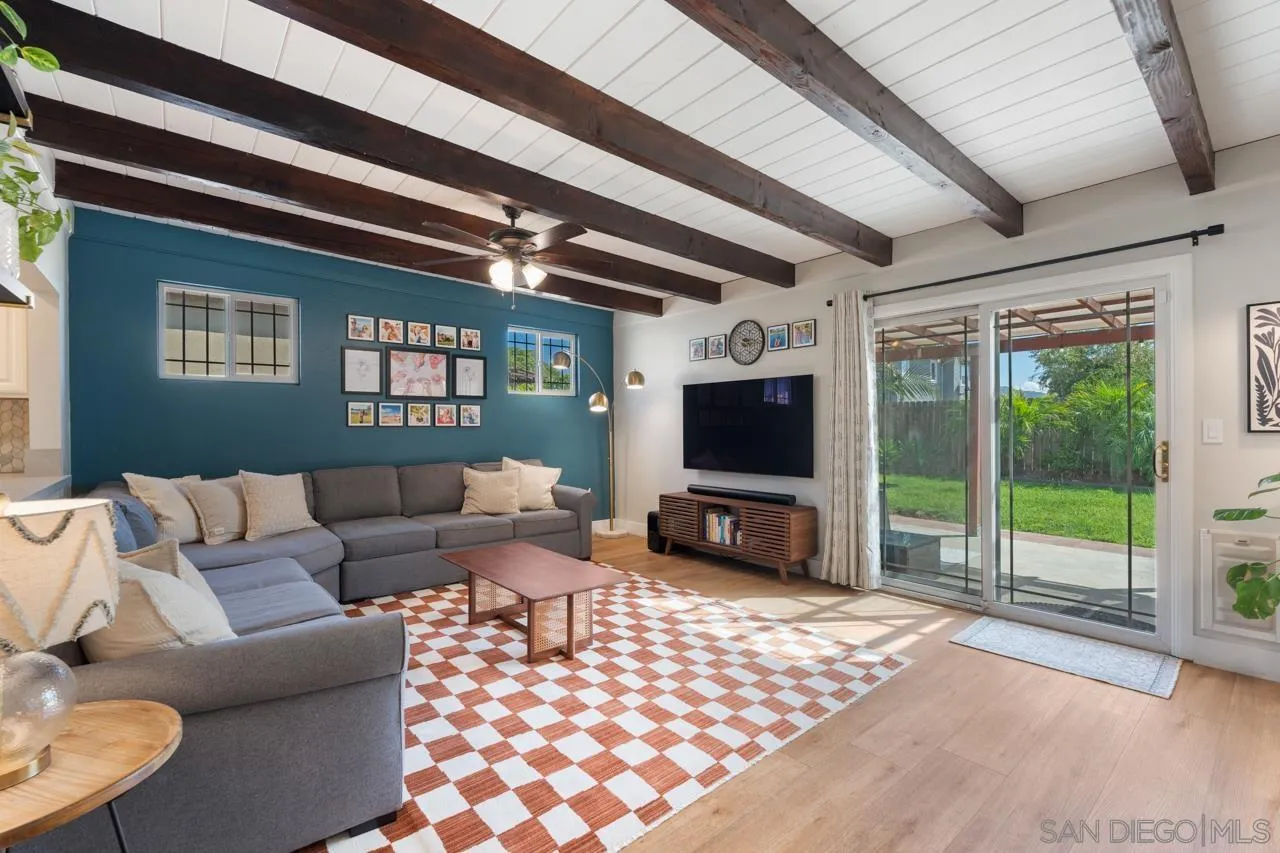 10113 Gem Tree Way Santee, CA 92071 - Photo 8 of 49 a living room with furniture a flat screen tv and a floor to ceiling window